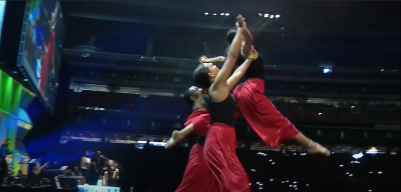 Two dancers lift another dancer in the air.