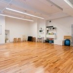 sunny studio with hardwood floor and movement equipment