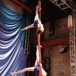 Two aerialists perform on silks 