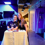 Photo of two young women standing at the podium greeting guests at the Two Can Do Gala 2019