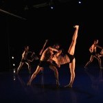 Group of dancers partnering on stage during a performance.