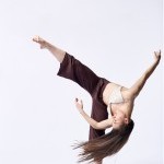 Dancer in maroon pants with leg in the air.