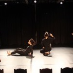 4 dancers dressed in black are performing in a performance showcase at the BAC