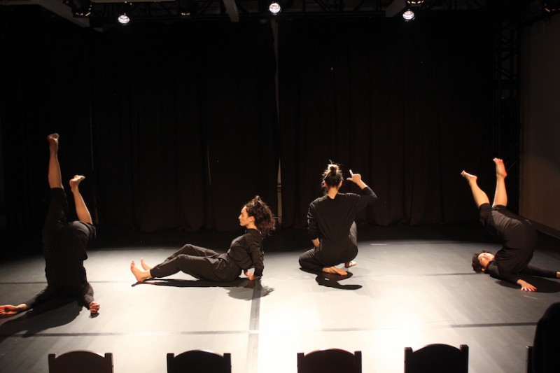 4 dancers dressed in black are performing in a performance showcase at the BAC