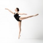 ballerina in black leotard arabesque