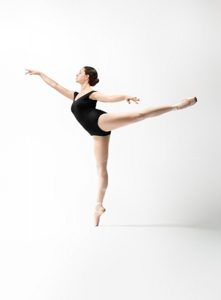 ballerina in black leotard arabesque