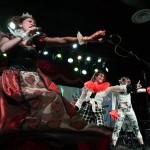 Red queen singing with 2 dancers