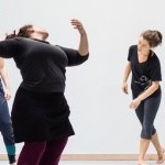 Alexandra Beller Spiraling in a dance studio, looking back at students who look on spiraling on their own.