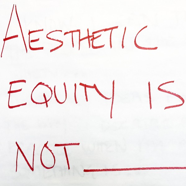 A large piece of white paper with the words "Aesthetic Equity is Not" written in red marker