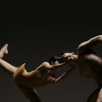 Two dancers pull apart from one another