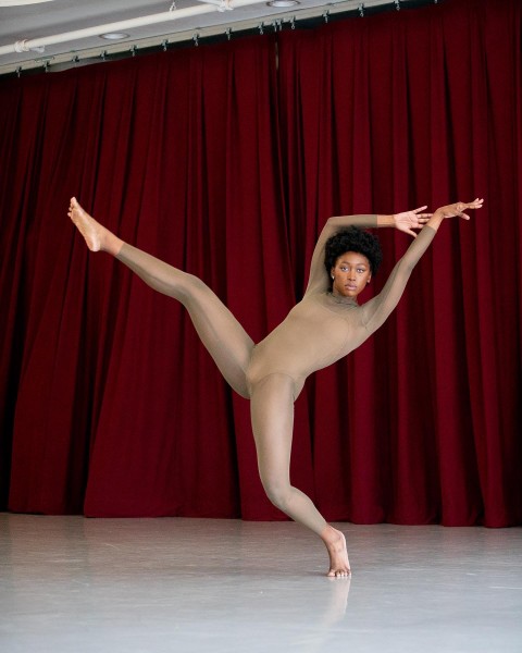 Dancer in tan unitard extends legs and arms