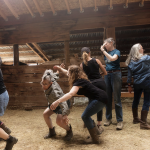 Dancers sharing space in an outdoor barn during a Physical Listening LAB.