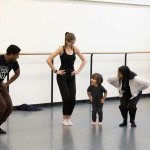 A young mover participating in NYCB Workshops bends their knees alongside NYCB Buddies.