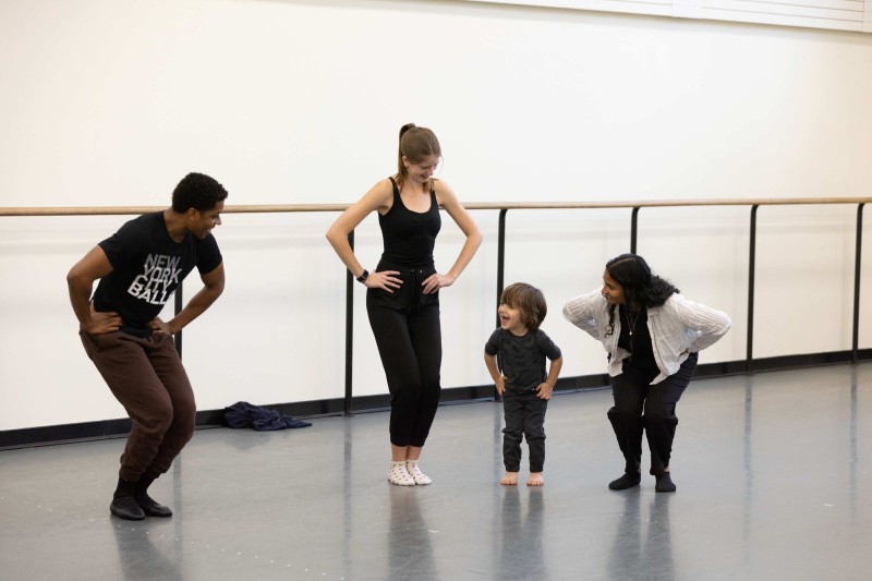 A young mover participating in NYCB Workshops bends their knees alongside NYCB Buddies.