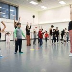 Dancers participating in NYCB Workshops reach their arms up into the air.