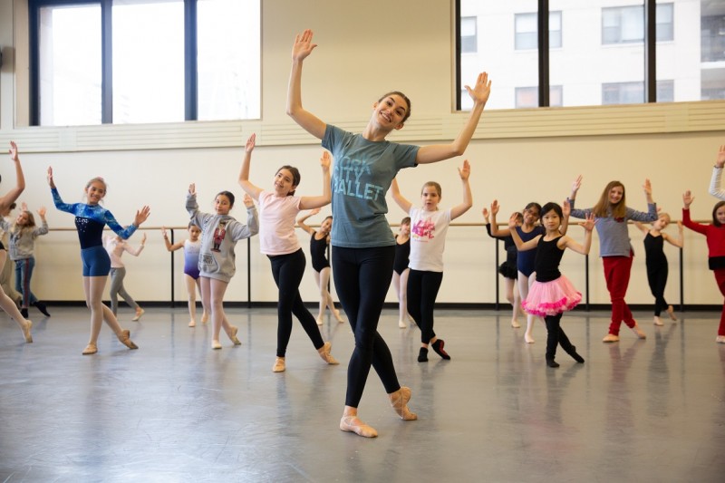 A NYCB artist leads young dancers standing in the B-plus position.