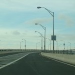 An upwardly sloping bridge with street lights on one side