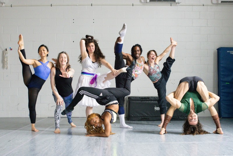 a group of 7 circus artists make silly poses standing in the studio 