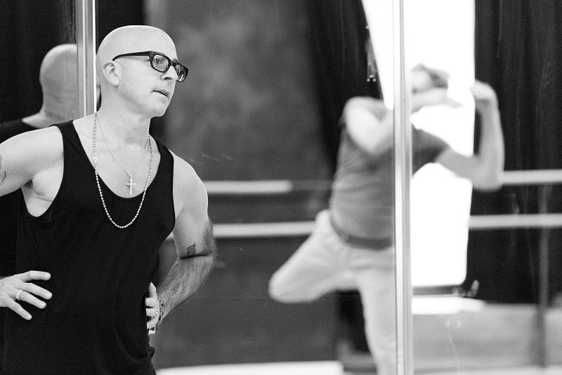 A black and white picture of Stephen Petronio directing a dancer during rehearsal.