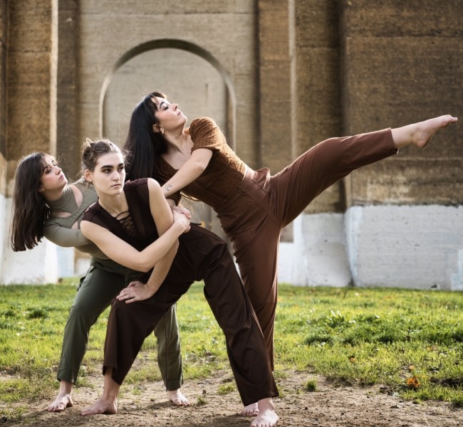 Three dancers leaning in a park
