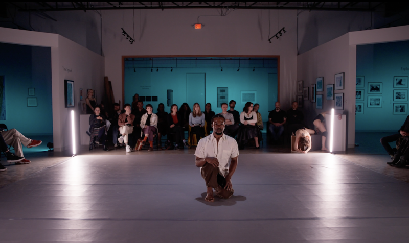 Image of a male dancing kneeling on a white floor