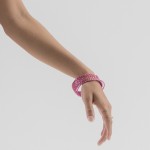 Forearm in "dola hasta," wearing pink bangles