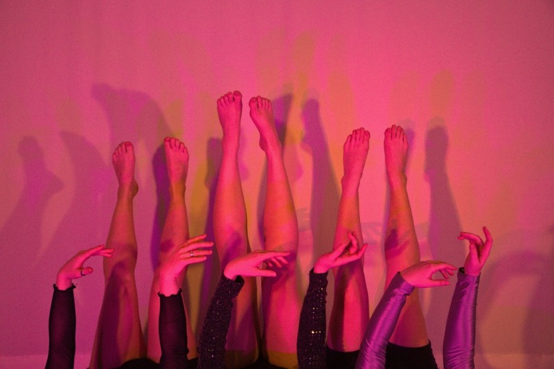 LEGS POINTING UPWARDS AND HANDS POINTING RIGHT WITH A RED HUE TINT