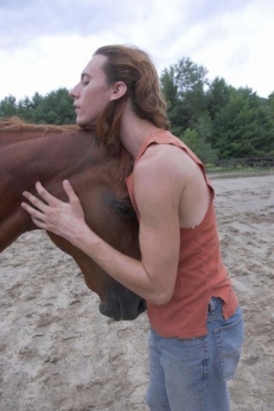 A person hugging a horse