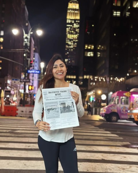 A lady holds a copy of the newspaper in Times Square