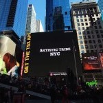 A billboard shows the logo of Artistic Tribe NYC