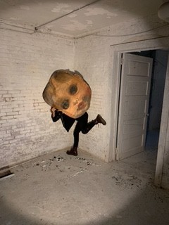 dancer holding a large painted head of a child