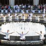 Dancers in white with arms upraised