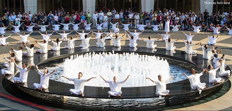 Dancers in white with arms upraised