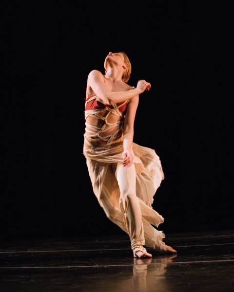 Female Dancer looking up in beige and red flowing costume 