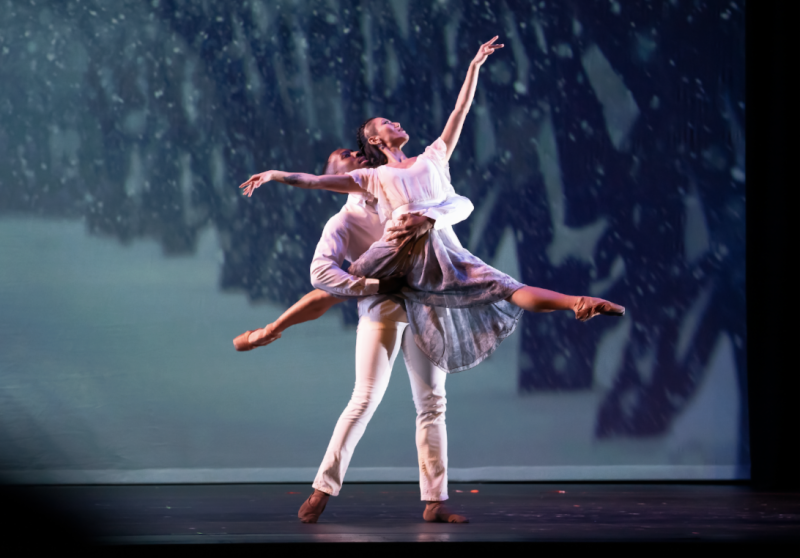 Two ballet dancers on stage; the male dancer lifts the female dancer, who extends her arm gracefully upward.