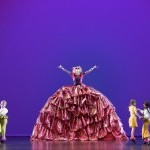 Mother Ginger in a bright red dress on stage.