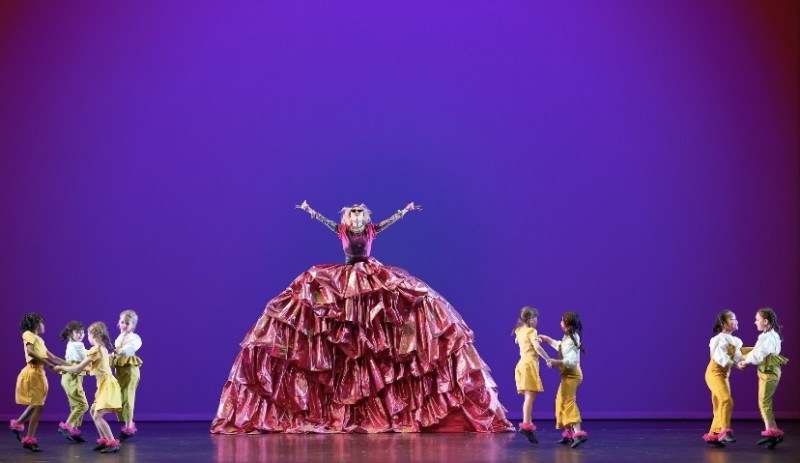 Mother Ginger in a bright red dress on stage.