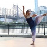 Dancer with arm and leg up in front of Queensboro bridge