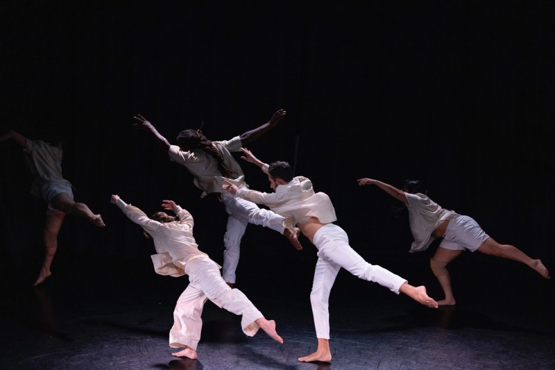 Image with 4 dancers facing back and leaning on one leg and arms extended in front of them