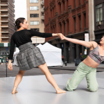 Two dancers holding hands leaning away from each other