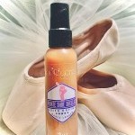 Bottle of pointe shoe shellac with pointe shoes against chiffon