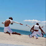 three men jumping at the beach in white costumes