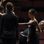 A group of dancers onstage in a rehearsal