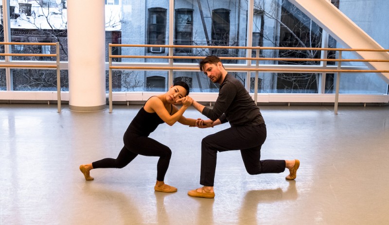 Two dancers in connected shape in dance studio. 