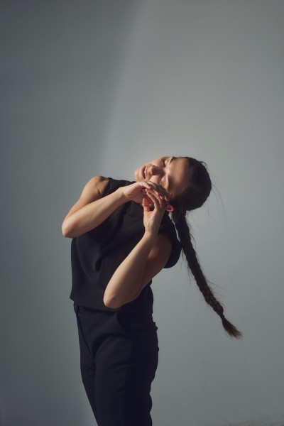 Image of Nicole von Arx dancing in front of a white wall. 