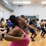 Dance class filled with students dancing and enjoying themselves 