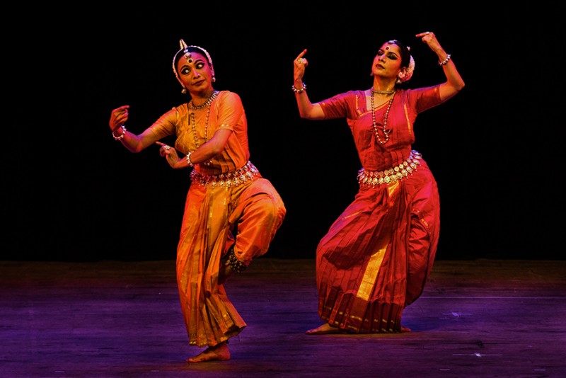 Two women in traditional Indian dress dancing.