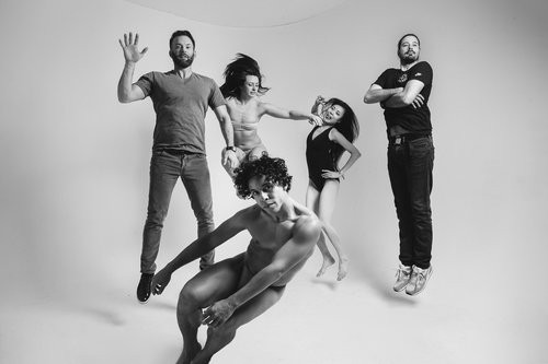 Black and white photo of five people jumping in the air
